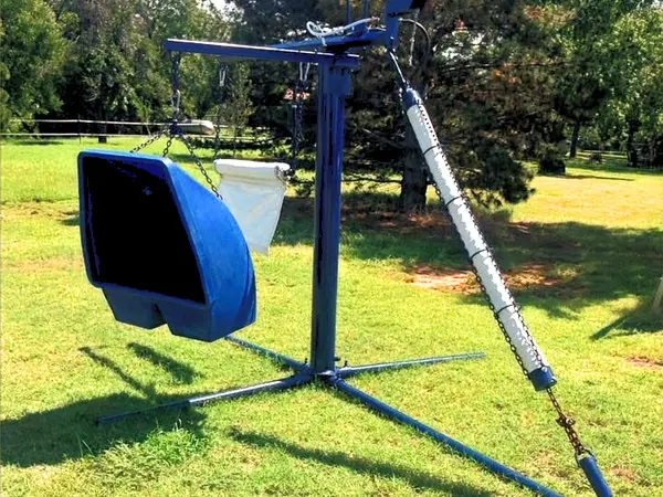 Blue Lewis cattle oiler set up on a mowed lawn